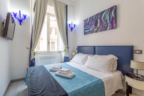 Un dormitorio con una cama azul con toallas. en White Vatican, en Roma