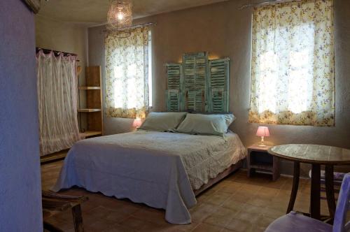 Locanda degli Ultimi في Vignale: غرفة نوم بسرير ونوافذ وطاولة