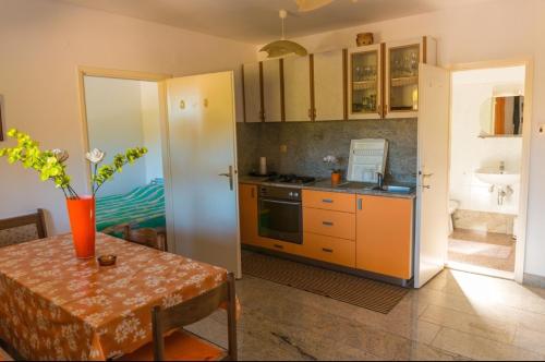 a kitchen with a table and a stove top oven at Kuća za odmor- Simona in Punta Križa