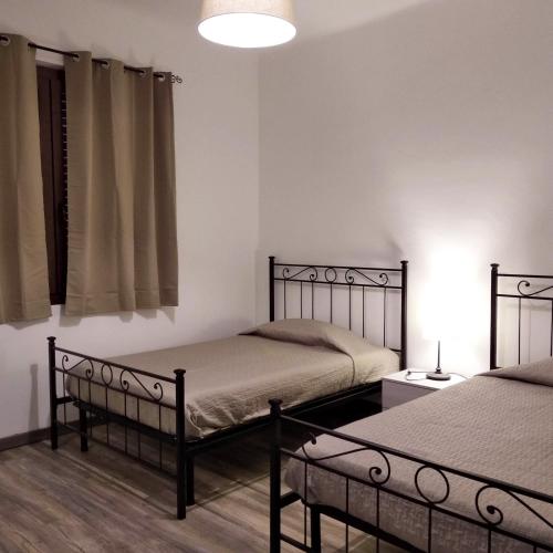 a bedroom with two beds and a lamp and a window at Casa Lin in Celle Ligure