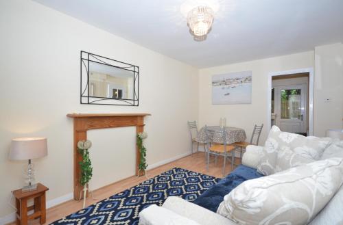 un soggiorno con divano bianco e camino di Bright Stylish 2 Bedroom Garden Apartment South Belfast close to Everything a Belfast