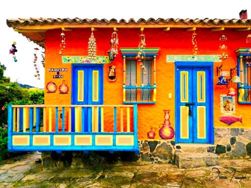 a colorful house with blue doors and windows at Casa Posada Maestro Carlos Aranguren in Duitama