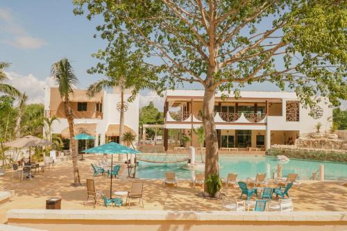 a resort with a pool and chairs and a building at Casa Kaoba Hotel & Suites in Playa del Carmen