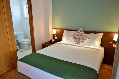 a bedroom with a bed and a bathroom with a toilet at Casa São Bernardo de Claraval in Geres