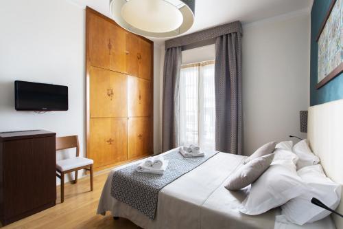 a bedroom with a bed and a tv and a window at Residenza Wagner in Palermo