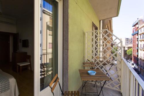 a room with a balcony with a table and a window at Residenza Wagner in Palermo