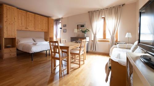 a room with a table and a bed and a bedroom at Italianway - Milano 48 in Bormio