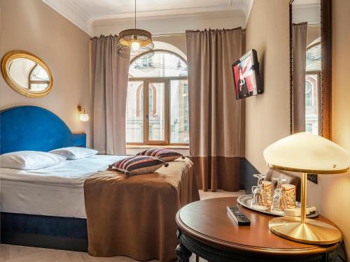 a hotel room with a bed and a table at Greenwich by Friends in Saint Petersburg