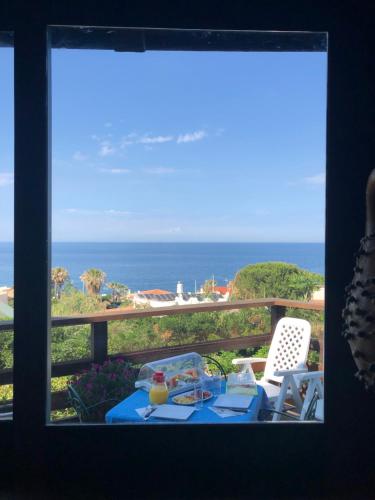 een raam met een tafel en stoelen en uitzicht op de oceaan bij Una Finestra sul Mare in Augusta