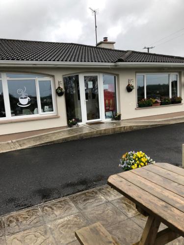 een huis met een houten bank ervoor bij June’s b&b in Kilkelly