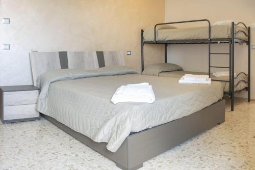 a bedroom with two bunk beds with towels on them at Alba sul Mare Guest House in Massignano