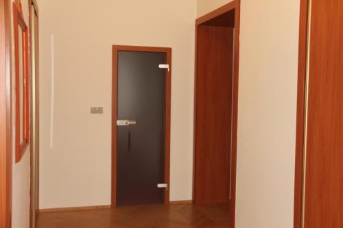 a hallway with a black door in a room at Jurincom apartments Sadová in Karlovy Vary