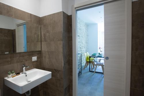 a bathroom with a sink and a mirror and a table at Funduq ospitalità iblea in Pozzallo