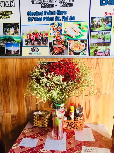 a vase filled with flowers sitting on a table at Hoa Mau Don Homestay in Hoi An