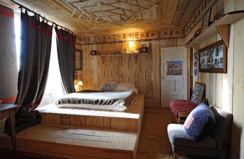 um quarto com uma cama, uma janela e uma cadeira em Comptoir d aubrac em Aubrac