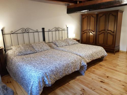 a bedroom with a bed and a wooden floor at Casa en Orbó-Brañosera in Orbó