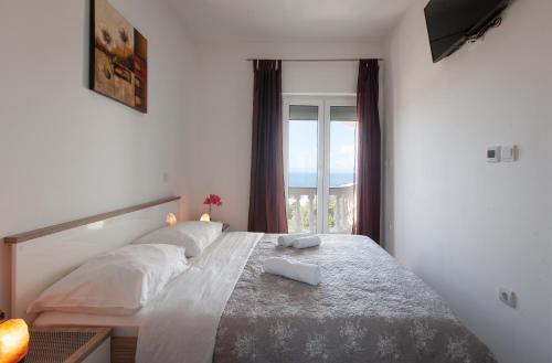 a bedroom with a large bed with a window at Apartments Ela in Makarska