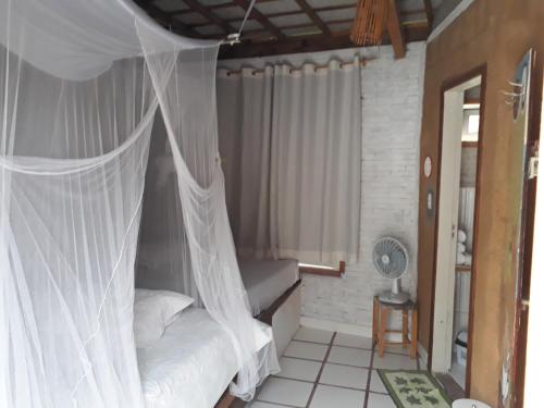 a bedroom with a bed with a mosquito net at Ilha de Mato in Vale do Capao