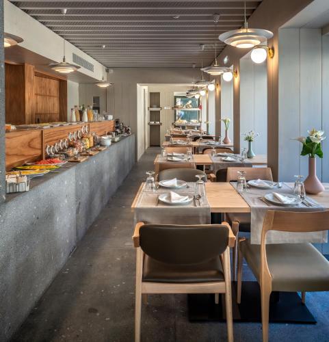 a restaurant with wooden tables and chairs and a counter at Porta Nova Collection House in Braga