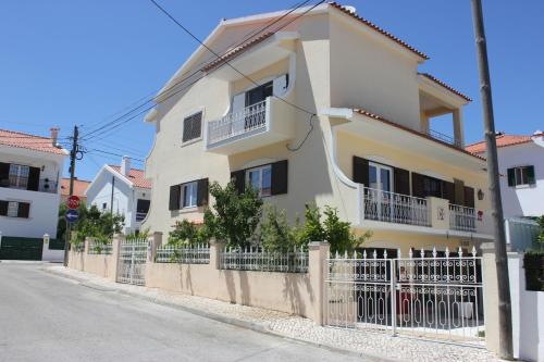 a yellow house with a fence in front of it at Casa em Palmela - Setúbal in Palmela