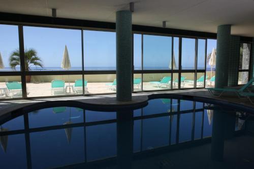 a swimming pool with chairs and a view of the ocean at Madeira Regency Cliff - Adults Only in Funchal