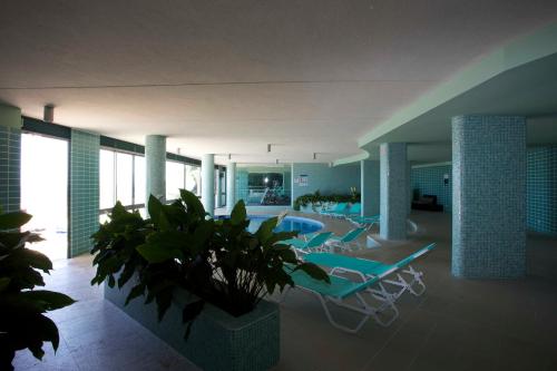 a lobby with chairs and a pool and a plant at Madeira Regency Cliff - Adults Only in Funchal