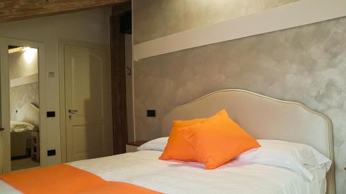 an orange pillow sitting on top of a bed at Duomo Attic (rooms) in Ravello