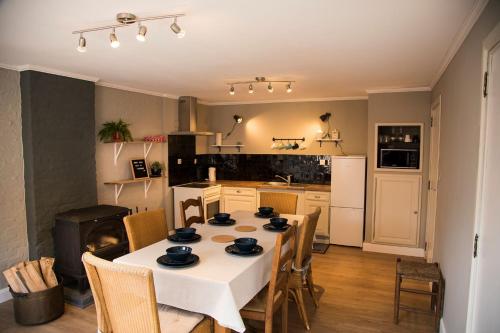 uma cozinha com uma mesa com uma toalha de mesa branca em 'T Dagwant em Geraardsbergen