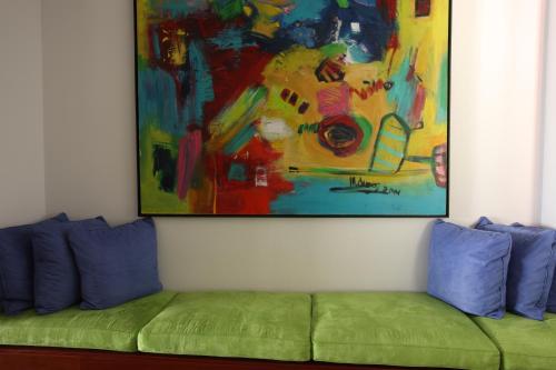 a painting above a green couch in a room at Madeira Regency Cliff - Adults Only in Funchal