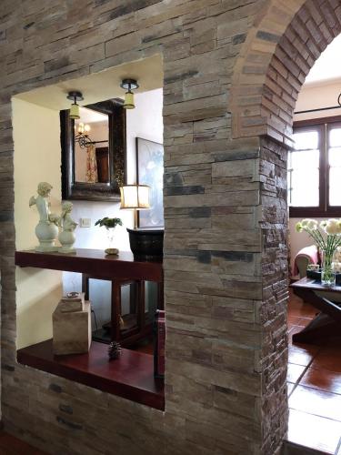 a stone wall in a room with a table and a mirror at LOFT RURAL in Tegueste