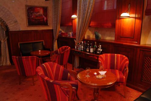 a restaurant with red chairs and a table and a bar at Grotthuss Boutique Hotel Vilnius in Vilnius