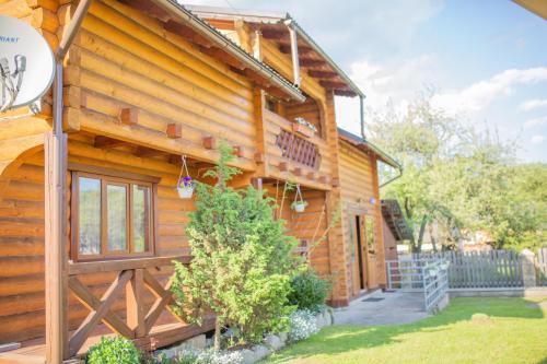a log cabin with a porch and a stairway at Lucy in Yaremche