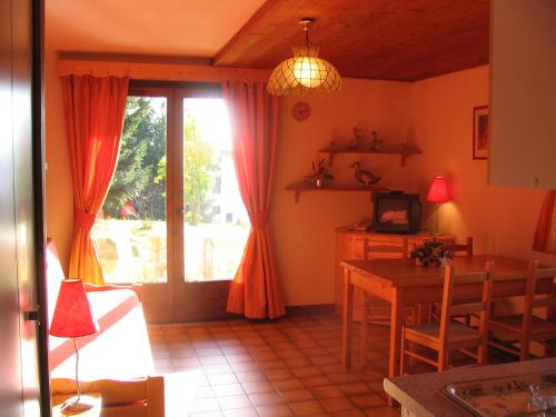 a living room with a table and a dining room at CHALET LA LICORNE 1 - pied des pistes in Notre-Dame-de-Bellecombe