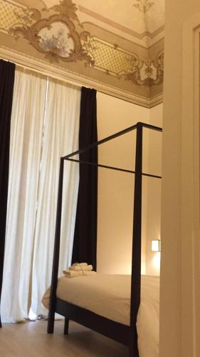 a bedroom with a canopy bed and a window at Gatto Bianco Duchessa in Bari