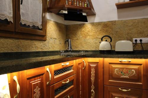 una cocina con armarios de madera y fregadero en Villa Cantos Colorados, en Ingenio