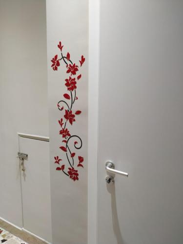 a bathroom with a shower with red flowers on the wall at Aspra al delfino blu in Bagheria