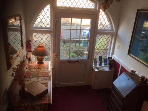 um corredor com uma porta e uma lâmpada sobre uma mesa em Haven House em Largs