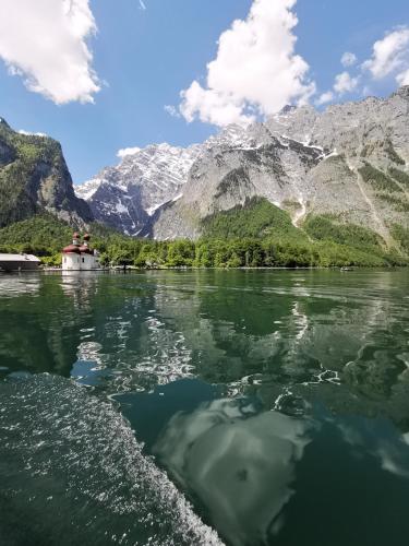a boat on the water with mountains in the background at Ferienwohnung Lohnerlehen in Marktschellenberg