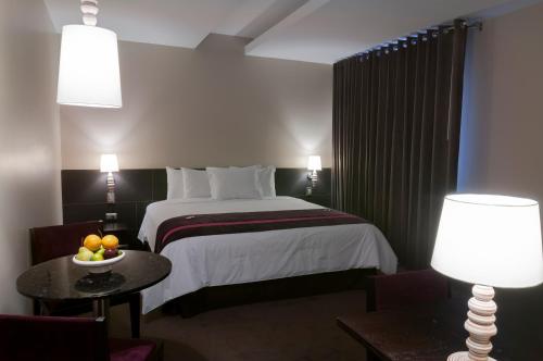 a hotel room with a bed and a table with a bowl of fruit at Arawi Miraflores Prime in Lima