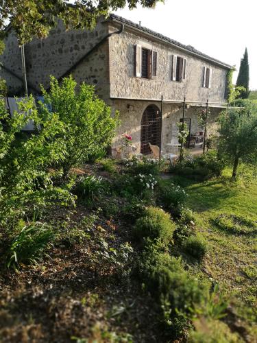 an old stone house with a garden in front of it at Casa Crevole in Palazzina