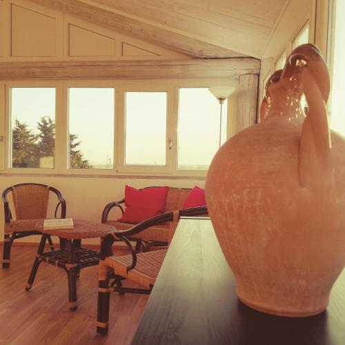 a vase sitting in a room with a table and chairs at Agriturismo Masseria Cannella in Lesina