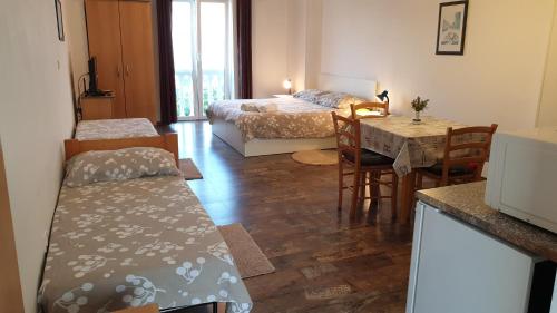 a living room with a bed and a table and chairs at Apartments Kolmanic, sea view, free privat parking in Ičići