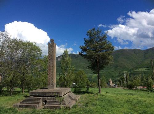 a monument in a field with mountains in the background at Rubina Bed and Breakfast in Tatʼev