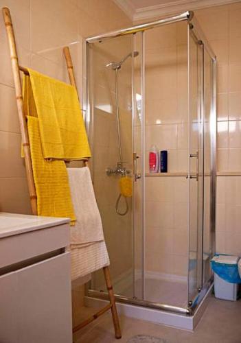 a bathroom with a shower with a glass door at A Casa dos Girassóis in Cuba