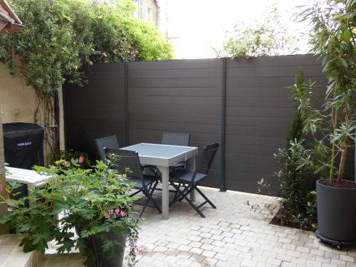 a patio with a table and chairs in front of a fence at LE LOGIS ST PERE in Sancerre