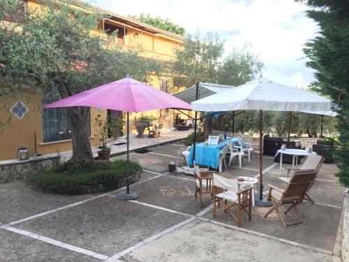 a patio with tables and chairs and umbrellas at LA CORTE DEL MULINO 1725 in San Salvatore Telesino