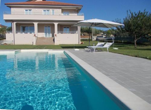 Casa con piscina y sombrilla en VILLA LAURO LUXURY B&B en Castellabate