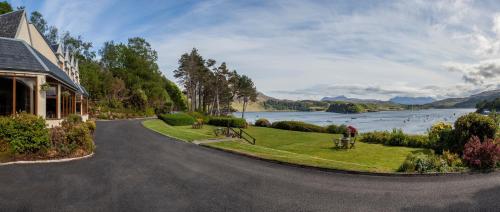 a house on a road with a view of a lake at Cuillin Hills Hotel in Portree