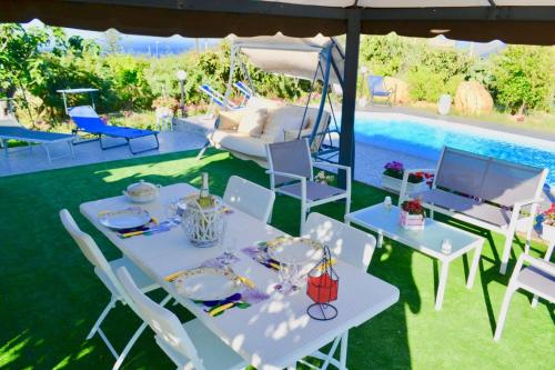 a white table and chairs in a yard with a pool at * * * VILLA ANNALISA * * * in Casteldaccia