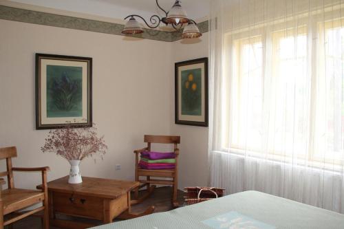 a living room with a table and a window at Fogadó a Suttogóhoz in Nagykörů